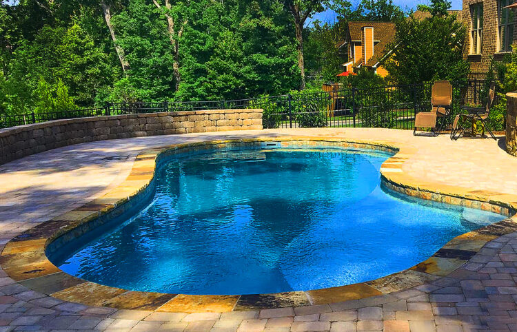 pool with black wall and pavers